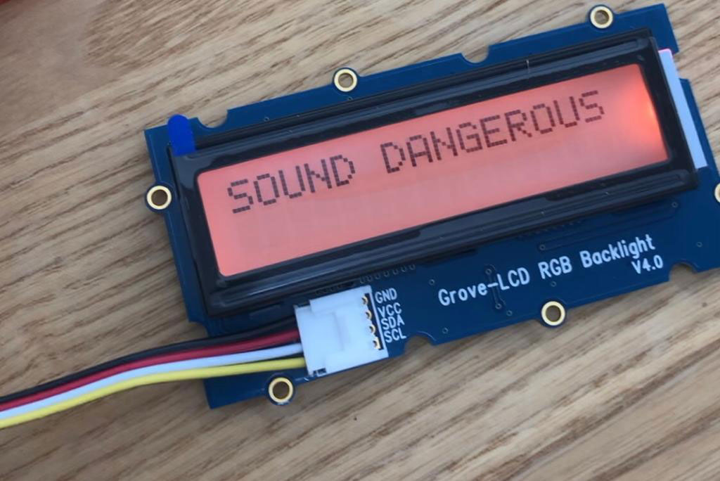 An LCD display with a red background displaying “SOUNDS DANGEROUS”.